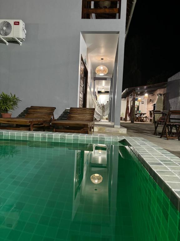 ein Haus mit einem Pool und einigen Stühlen in der Unterkunft Flat Sonhos de Milagres in São Miguel dos Milagres