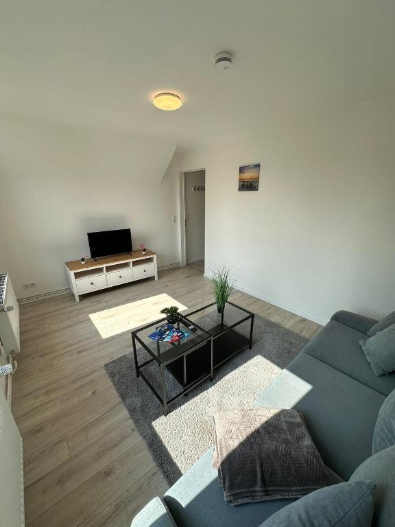 a living room with a couch and a table at Modernes Apartment in Ruhiger Lage in nähe des Fischereihafens in Bremerhaven