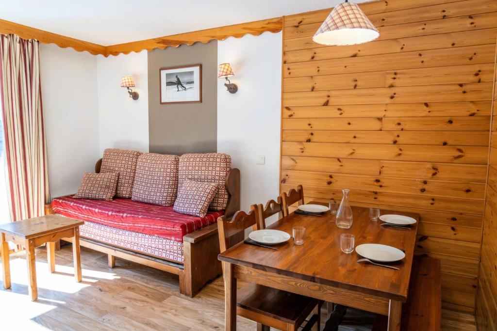 une salle à manger avec une table et un canapé dans l'établissement Résidence Les Hauts De Preclaux - Appartement 6 couchages au coeur des Orres 1800 MAE-4011, aux Orres