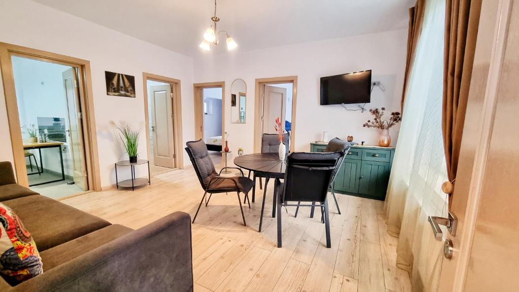 a living room with a table and chairs at KYD VILA - Studiouri si Apartamente la 100m de Plaja Debarcader in Eforie Nord