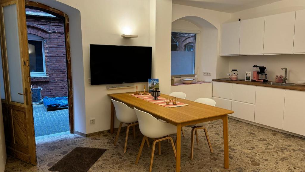 ケルンにあるMitten in der Kölner City - Design trifft Altbauのキッチン(テーブル、椅子、テレビ付)