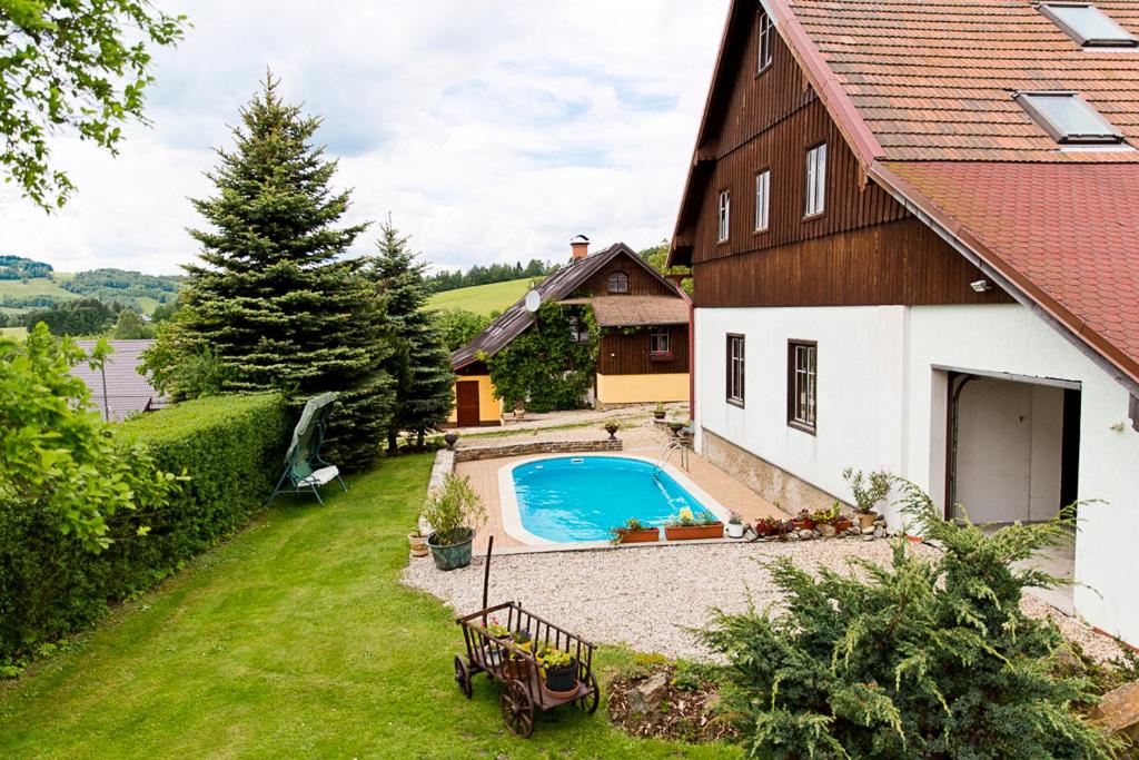 a house with a swimming pool next to a house at Apartment U Videmanů in Poniklá