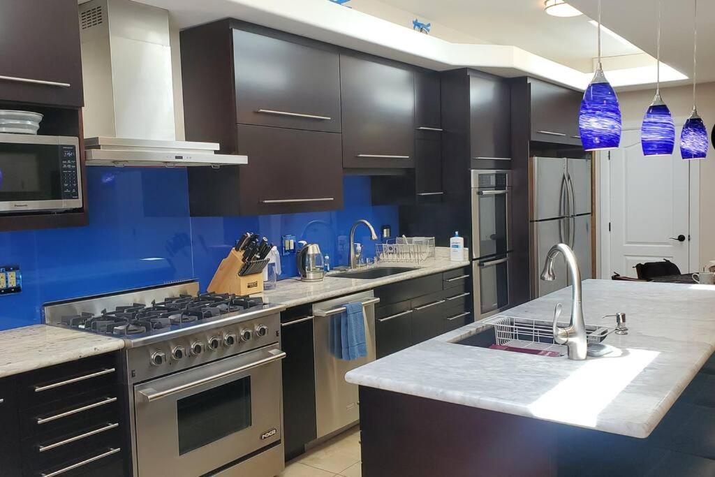 d'une cuisine avec des appareils électroménagers en acier inoxydable et des murs bleus. dans l'établissement Cozy SF Home 4 Bedroom 2 Bath, à San Francisco