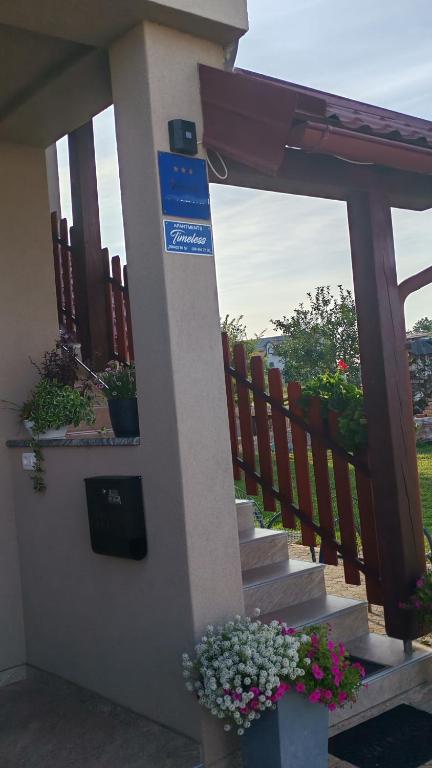 戈斯皮奇Timeless的一栋有楼梯的房子，有鲜花和篱笆