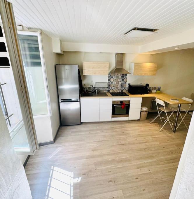 une cuisine avec un réfrigérateur et une table à l'intérieur dans l'établissement Le Marceau - Appartement confortable à Aubagne, à Aubagne