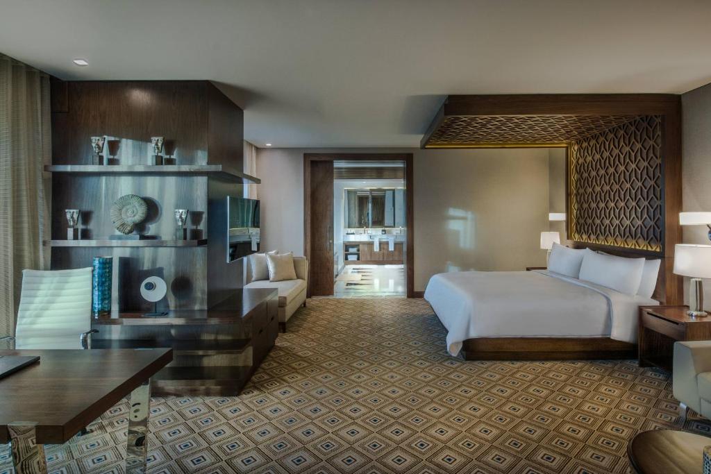 a hotel room with a bed and a living room at JW Marriott Hotel Santo Domingo in Santo Domingo