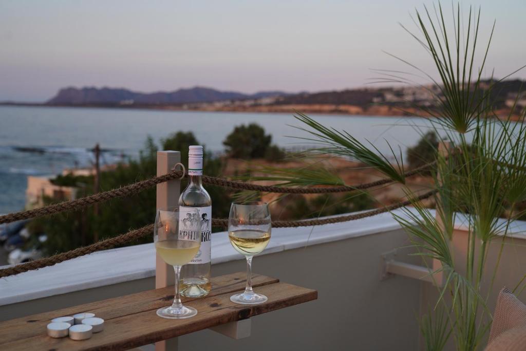 a bottle of wine and two glasses on a table at Porta Harenae Residencia in Chania