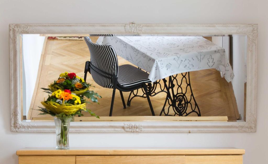 uno specchio con tavolo e sedia e un vaso con fiori di Villa Ars Vivendi a Gols