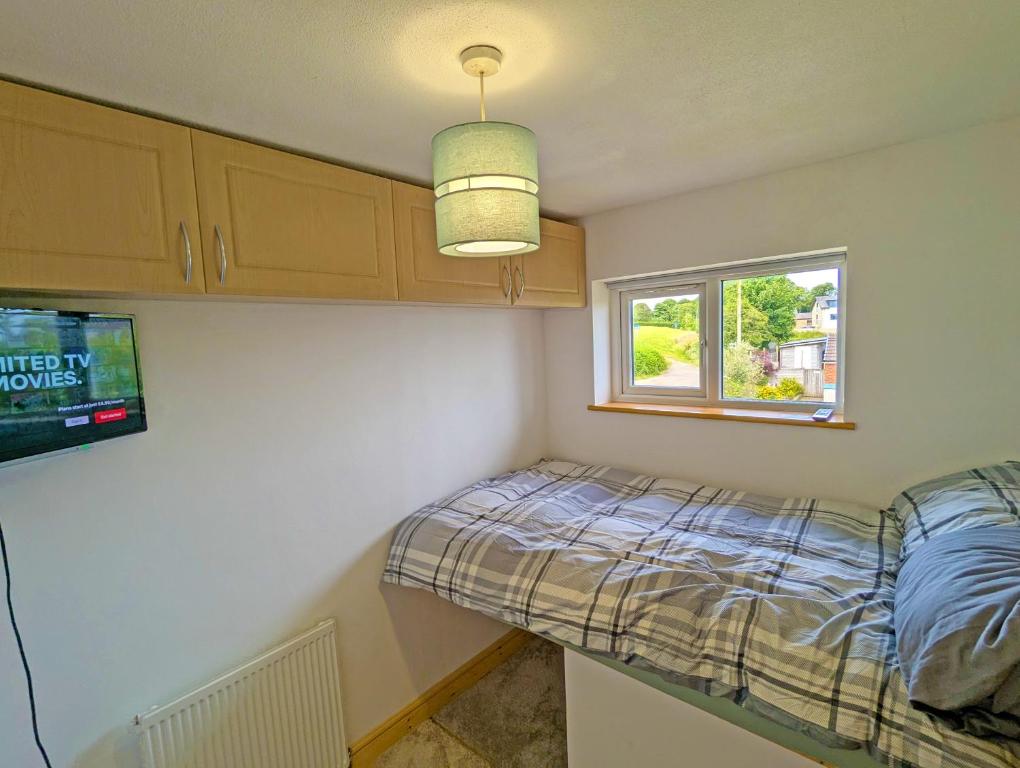a small bedroom with a bed and a window at Cosy Single Room l Smart TV l 5 Minute Walk from Train Station in Bolton