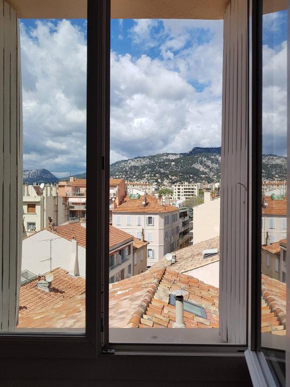 une vue d'une ville depuis une fenêtre dans l'établissement Private room with mountain view in an apartment of 3 rooms, à Toulon