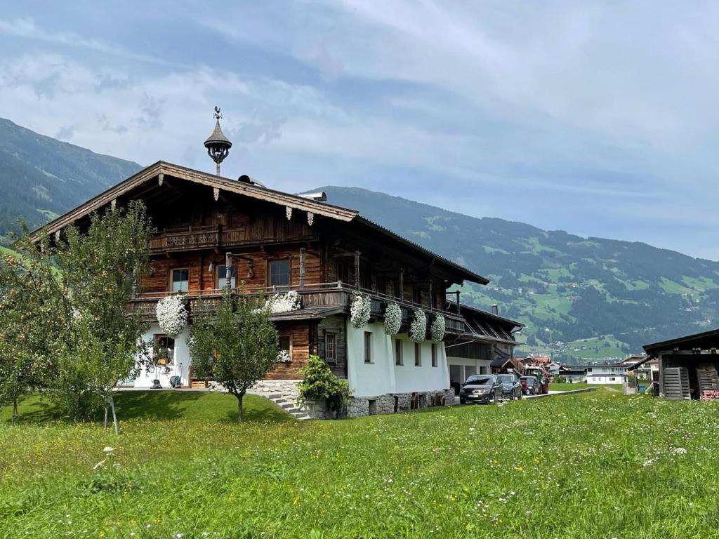 drewniany dom na polu z górami w tle w obiekcie Blick zum Mayrhofen w mieście Ramsau im Zillertal