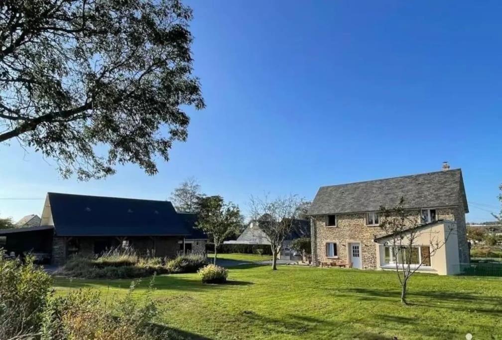 une vieille maison en pierre avec une grande cour dans l'établissement Lovely Normandy Charmante maison de campagne, à La Bigne