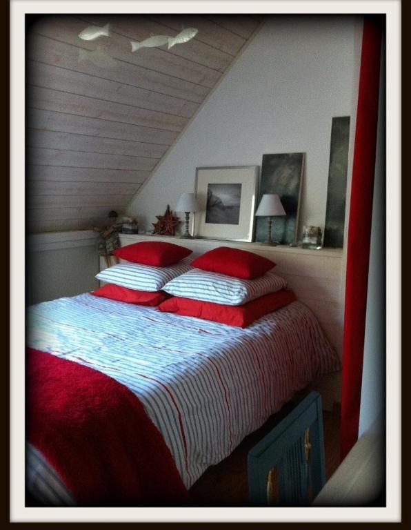 a bedroom with a large bed with red pillows at Les Agapanthes in Le Tour-du-Parc