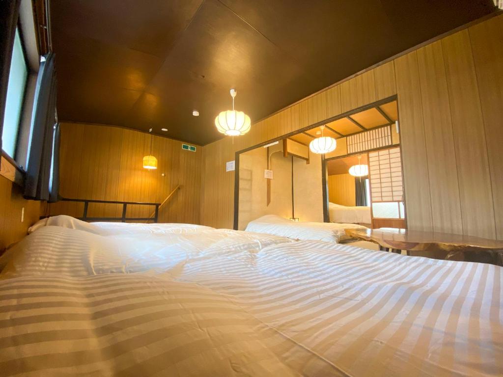 Nishinotōindōriにある百代家 京都 菅大臣町の2つの照明付きの客室内の大きな白いベッド