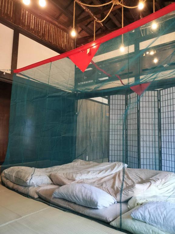 Postel nebo postele na pokoji v ubytování 古民家おばあちゃん家Grandma's HouseYugawaraHakoneAtami