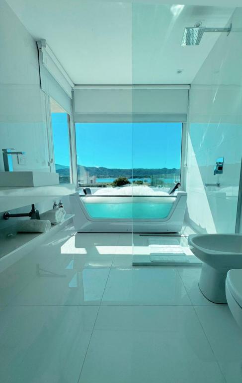 a white bathroom with a tub and a toilet at Serena Boutique Potrero Garay in Potrero de Garay