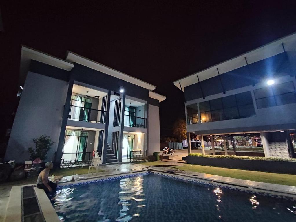 a man standing in a swimming pool in front of a house at Enap Machang in Macang