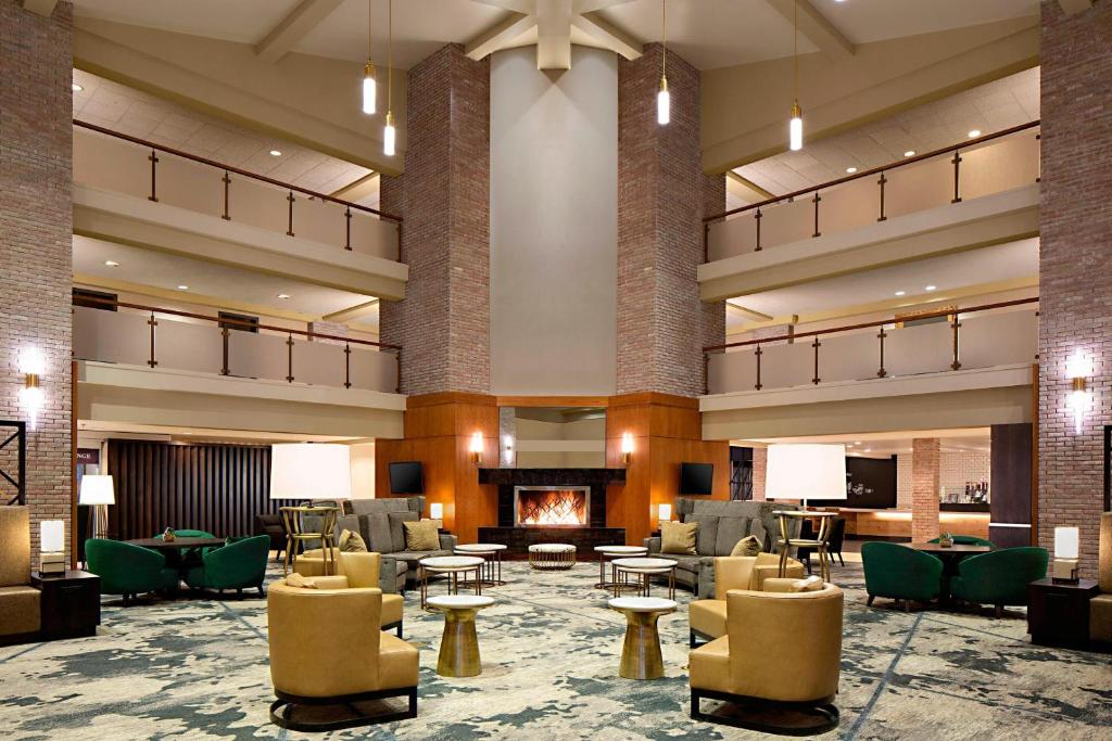 eine Lobby mit Sofas und Stühlen und einem Kamin in der Unterkunft Lincolnshire Marriott Resort in Lincolnshire