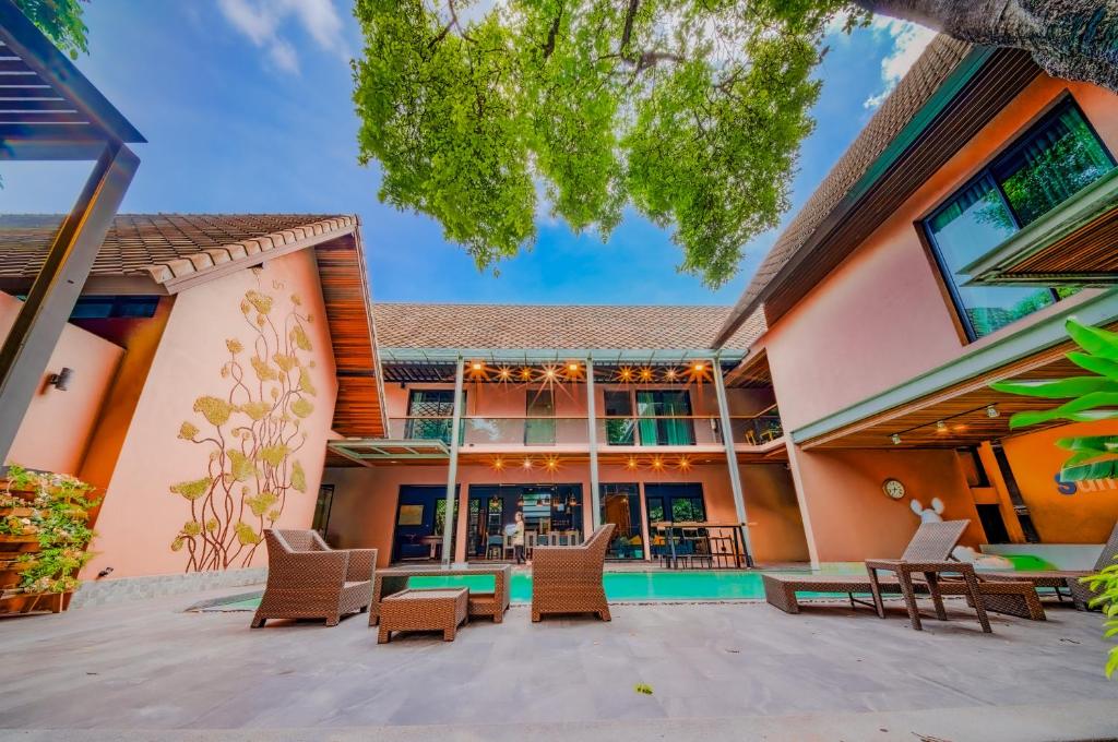 an exterior view of a building with chairs and tables at 189summer villa曼谷中心Asok&Thong Lor顶级豪宅庄园泳池别墅 in Bangkok
