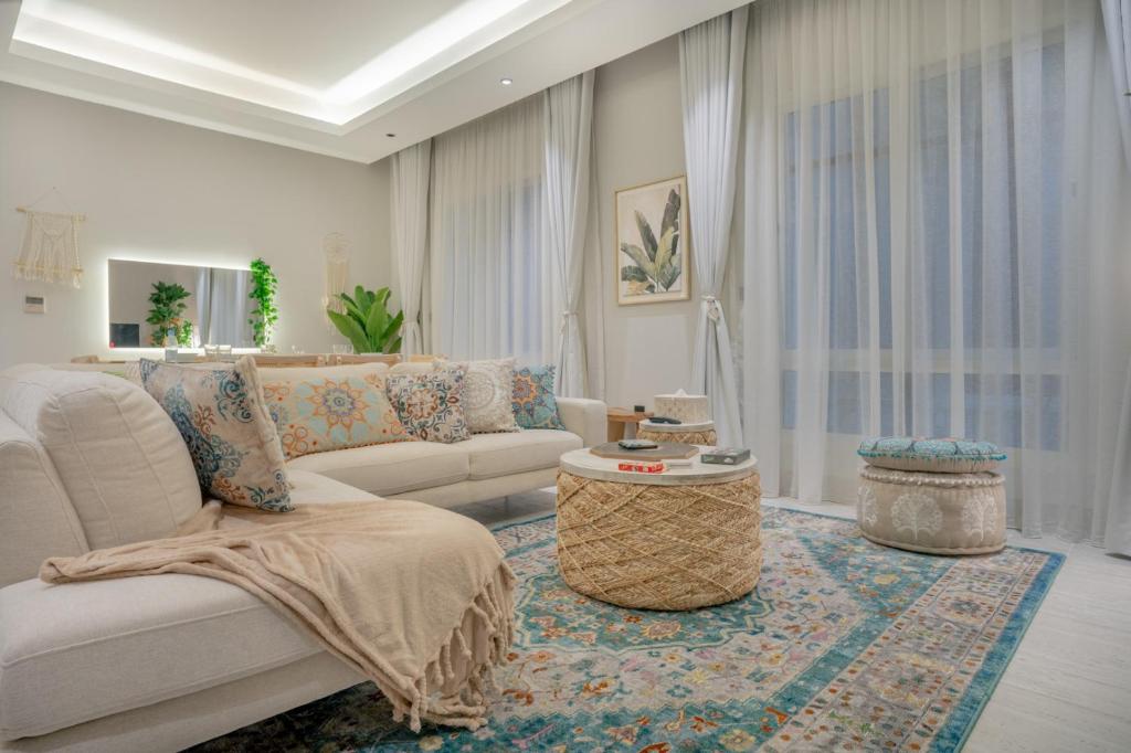 a living room with a couch and a table at Layali Properties - Boho Oasis 3BR Apt - Convention and Exhibition Center in Riyadh