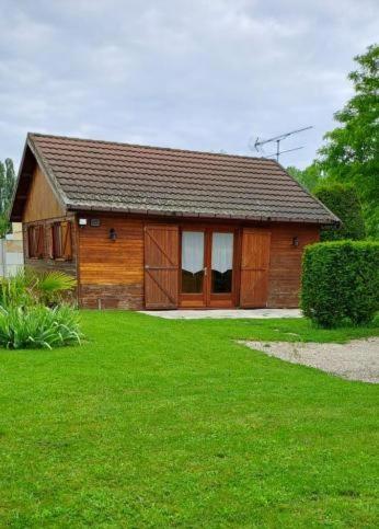 une petite maison en bois avec une cour verdoyante dans l'établissement Chalet, à Savières
