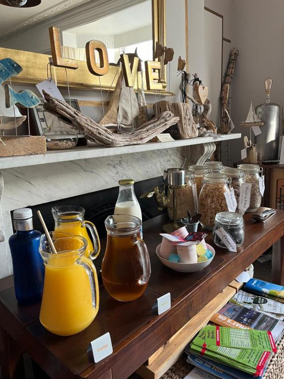 a shelf with jars of orange juice on it at Kelston Guest House in Weymouth