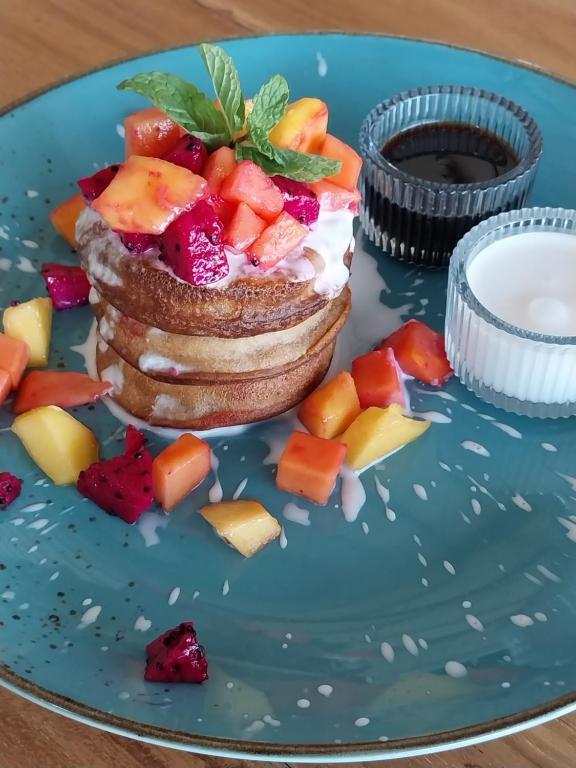 a blue plate with a pancake with fruit on it at Spaces Bali Unique Boutique Hotel in Munggu