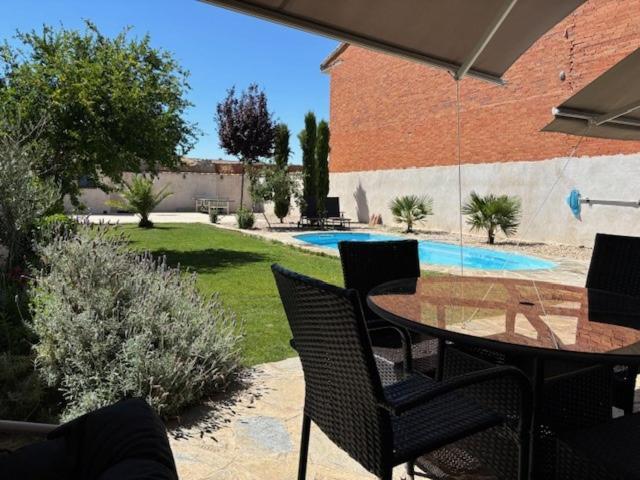 a patio with a table and chairs and a pool at Villa Mandrés. Casa con jardín y piscina. Proximo a Puy Du Fou. in Totanés