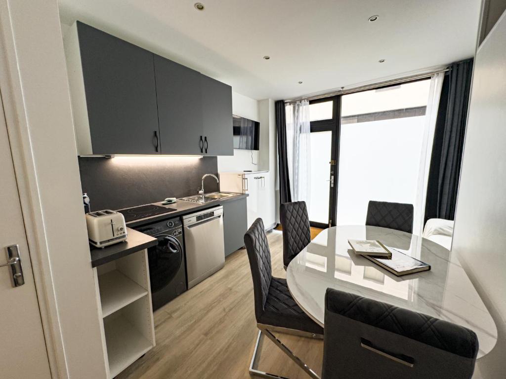 une cuisine et une salle à manger avec une table et des chaises dans l'établissement PenBed - Montparnasse 1 - 3 pièces, à Paris