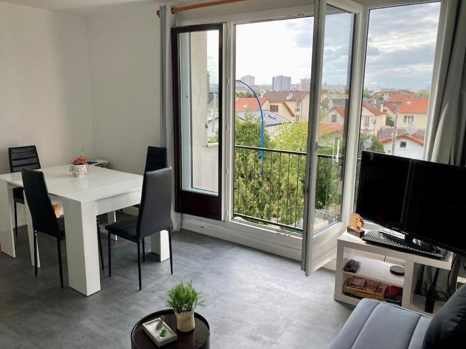un salon avec une table et une grande fenêtre dans l'établissement Studio superbe vue 1 canapé-lit, à Choisy-le-Roi