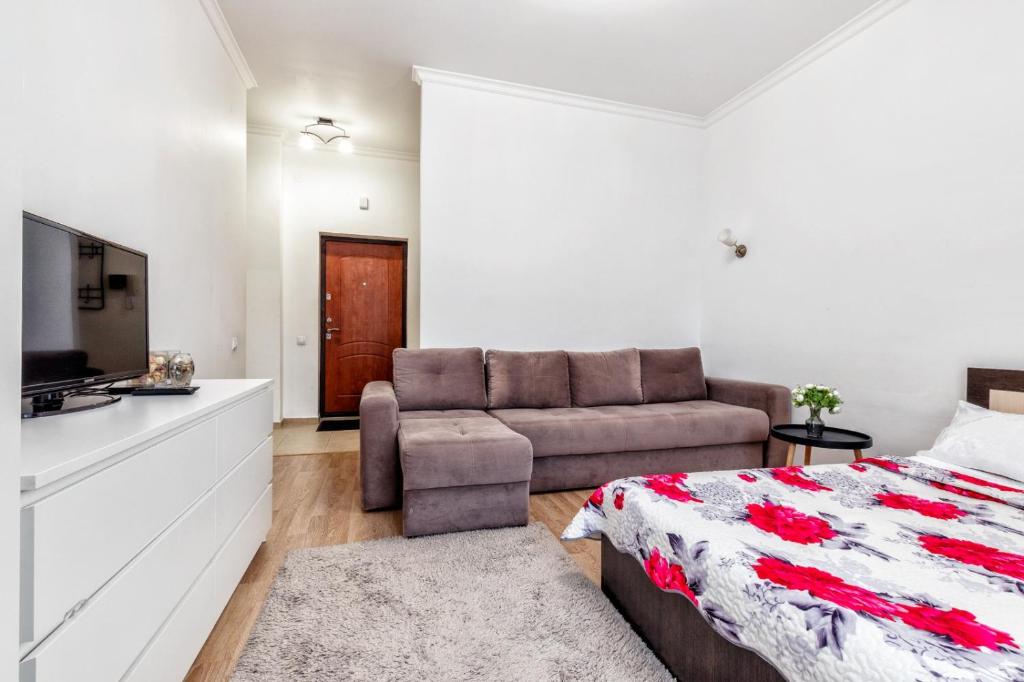 a bedroom with a bed and a couch at Apartments EXPO Residence in Taldykolʼ