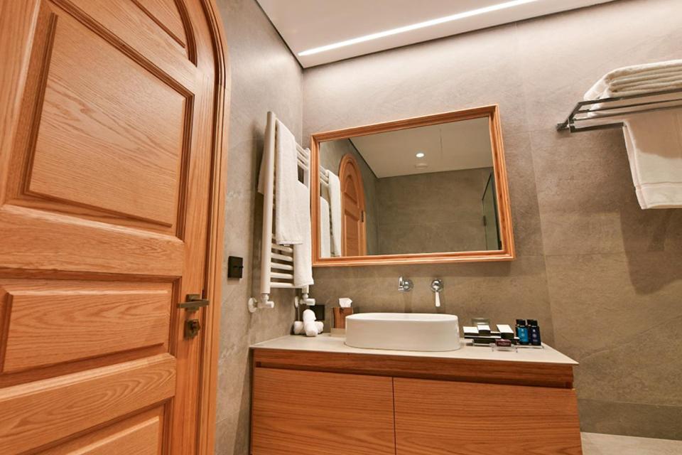 a bathroom with a sink and a mirror at KCOR Hotels in Ḩārat at Taḩtā