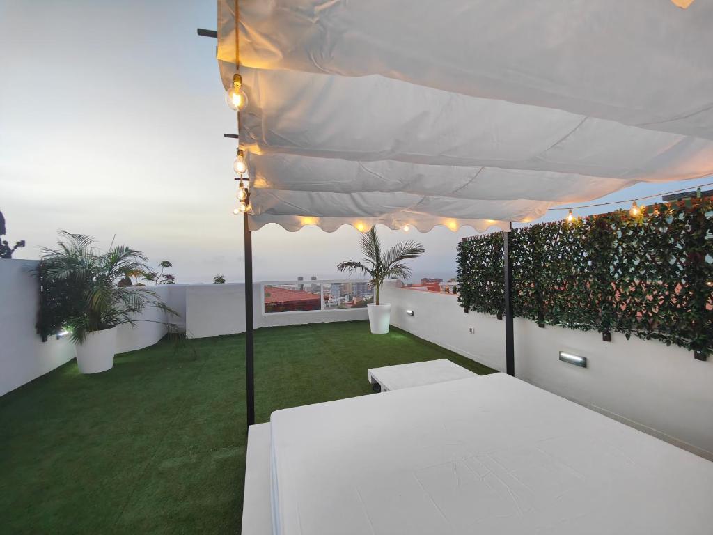 un balcon avec une table blanche et une pelouse verte dans l'établissement Casa 5 habitaciones con Solárium, à Santa Cruz de Tenerife