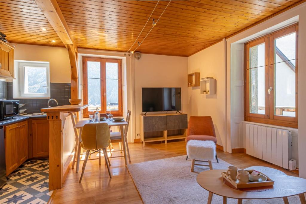 une cuisine et un salon avec une table et des chaises dans l'établissement Rimaye Blanche - A bright and cozy 1 bed apartment, à Chamonix-Mont-Blanc