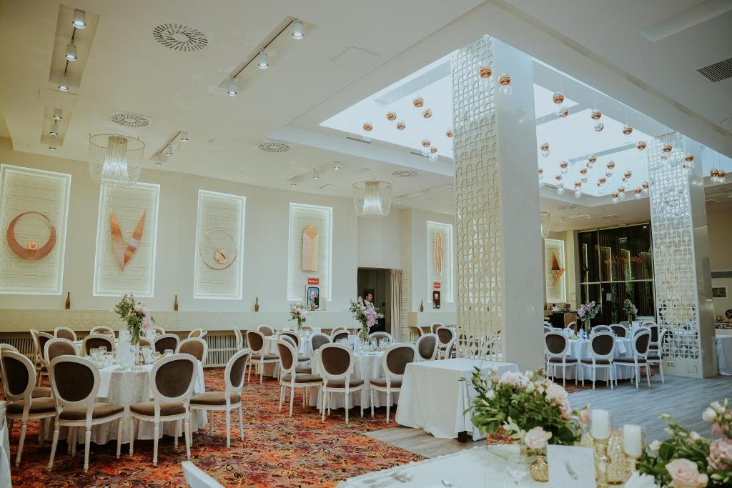 a banquet hall with white tables and chairs at Unirea Hotel & Spa in Iaşi