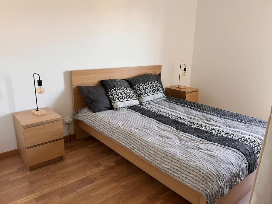 une chambre avec un lit avec deux oreillers dessus dans l'établissement t2 Gex Centre, proche Genève et station Mont Jura, à Gex