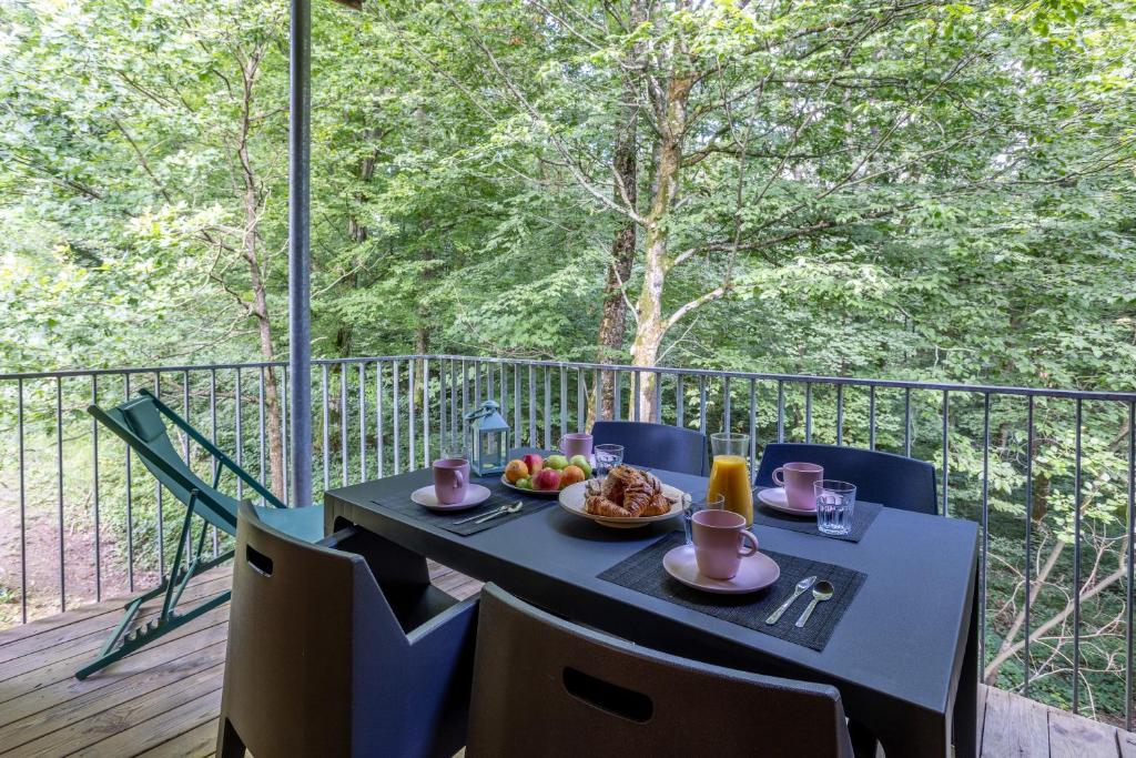 a table with a plate of food on a balcony at Le Sureau Noir S24B - Le Val Joly in Eppe-Sauvage