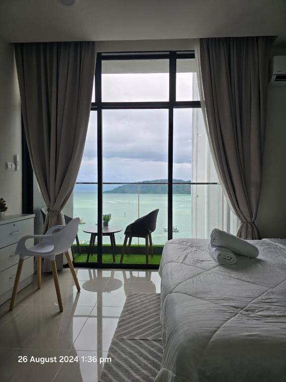 a bedroom with a large window with a view of the ocean at The Shore SeaView Center Kota Kinabalu Home Suites Studio in Kota Kinabalu
