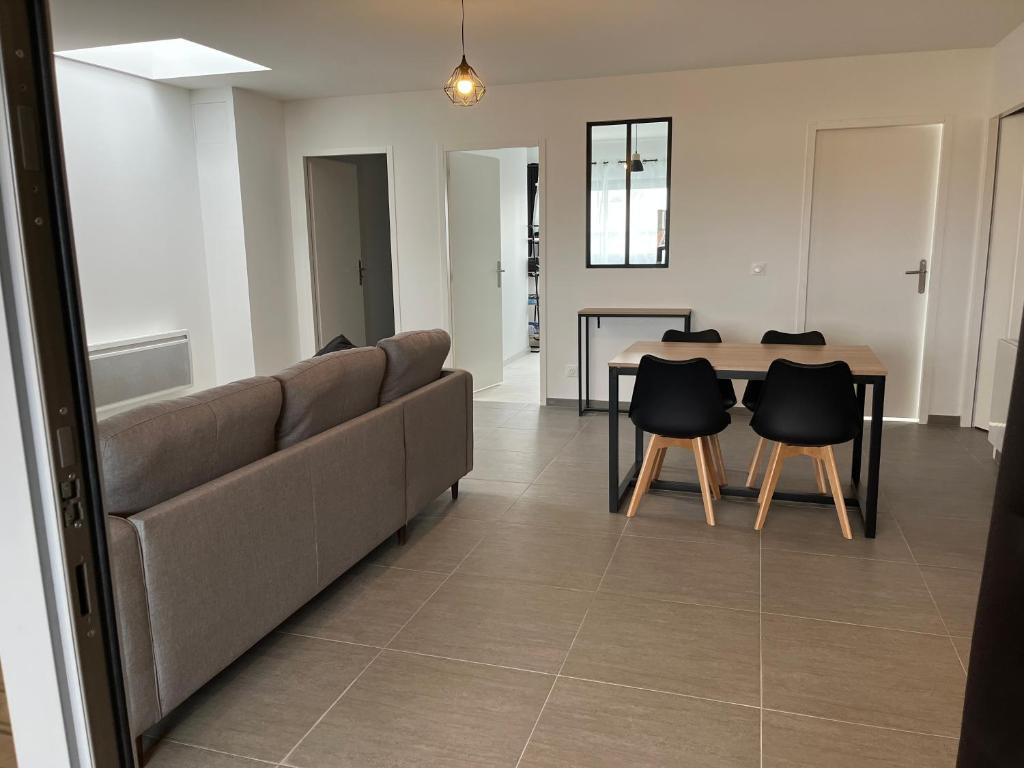 Una sala de estar con un sofá y sillas y una mesa. en Spa, en Marcheprime