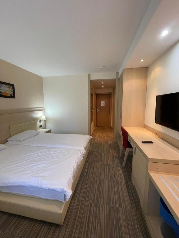 a hotel room with a bed and a desk and a television at Konaci Andjela Apartmani broj 108 in Kopaonik