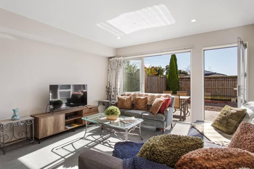 a living room with a couch and a tv at Handy Riccarton Hagley Park CBD 10 Mins in Addington
