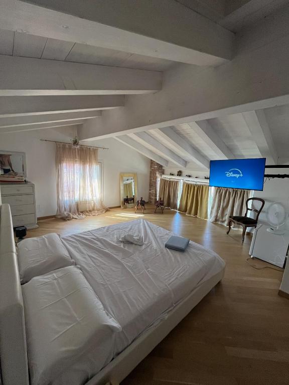 a large white bed in a room with a screen at Le Vele Del Cigno in Peschiera del Garda