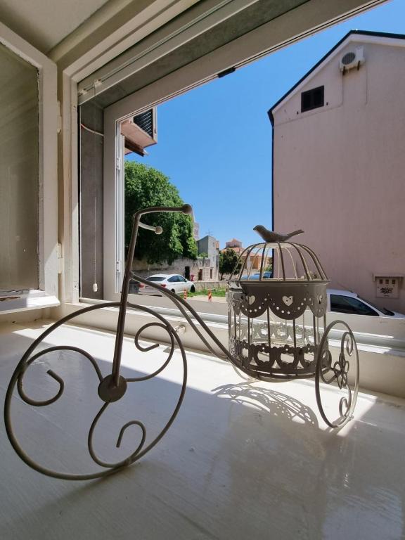 una jaula de aves sentada en la parte superior de una ventana en Sunset Apartment Petra, en Zadar