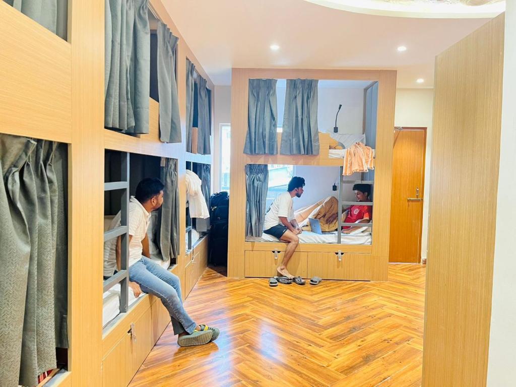 Dos hombres están trabajando en un dormitorio con espejos. en Joey&#39;s By The Ganges, en Rishīkesh
