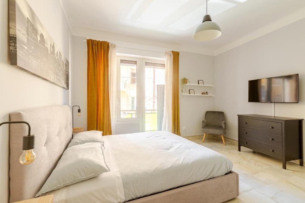 a bedroom with a bed and a television and a chair at 2 Camere Indipendenti, In pieno Centro con Veranda in Sanremo