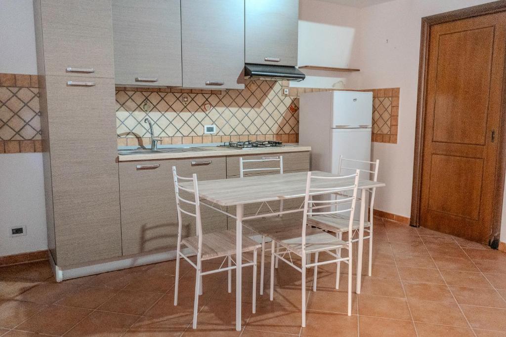 a kitchen with a table and chairs and a refrigerator at La discesa di San Giuseppe in Termini Imerese