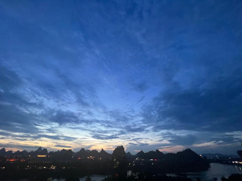a cloudy sky over a city and a river at 桂林依庐居民宿 in Guilin