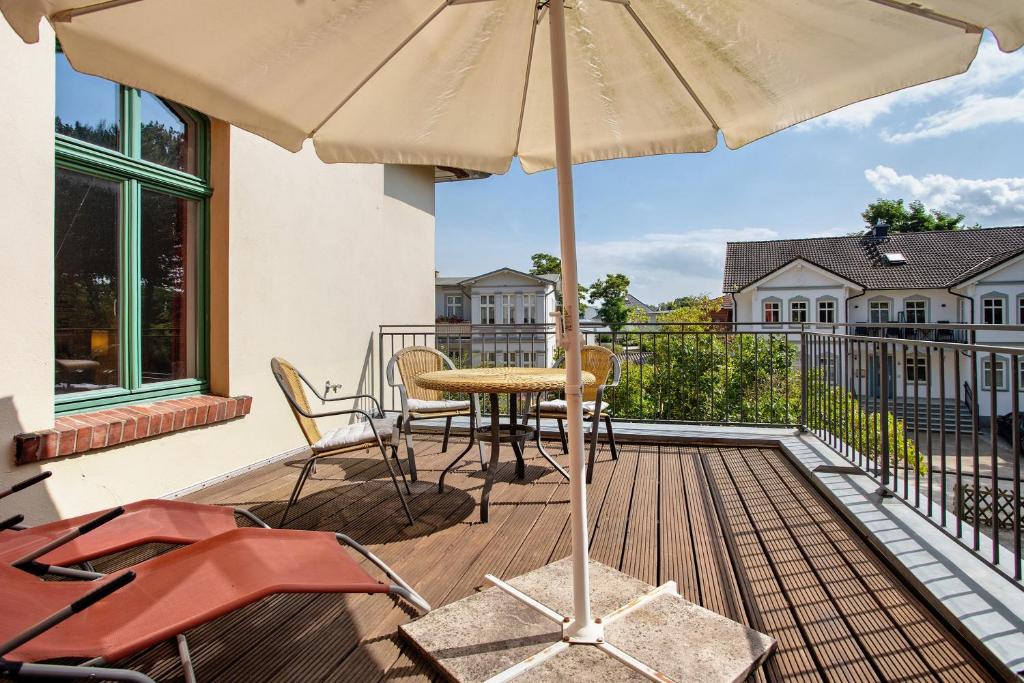 a patio with a table and an umbrella on a deck at Traumschlößchen 100 m vom Strand in Heringsdorf