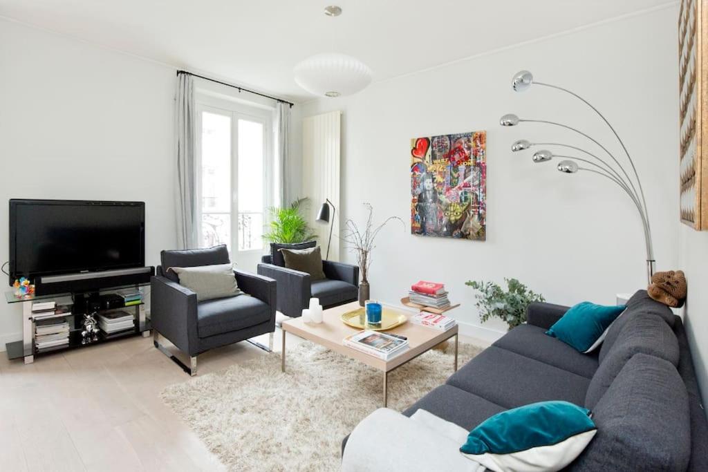 un salon avec un canapé, des chaises et une télévision dans l'établissement Appartement de luxe 1 chambre Tour Eiffel avec balcon, à Paris