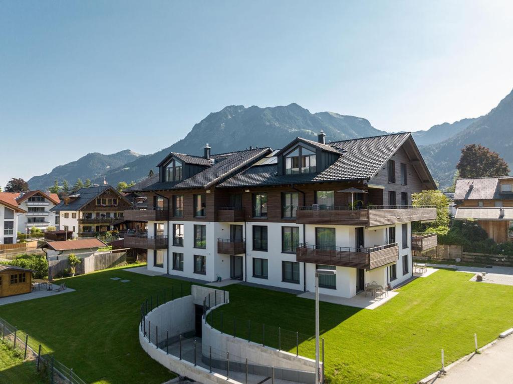 a large house with a large yard with green grass at Villa Alpjuwel in Oberstdorf